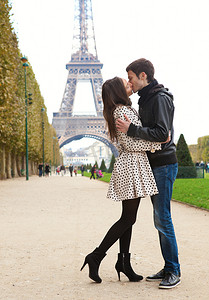 年轻浪漫情侣接吻在巴黎艾菲尔铁塔附近