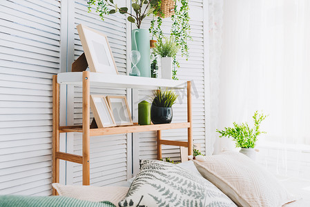 舒适明亮的房间角落装饰的各种对象, 如图片框, 植物和枕头