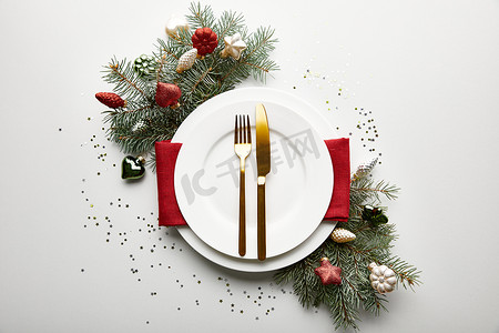 圣诞节标题框摄影照片_装饰松枝和五彩纸屑的白色背景圣诞餐桌的顶视图