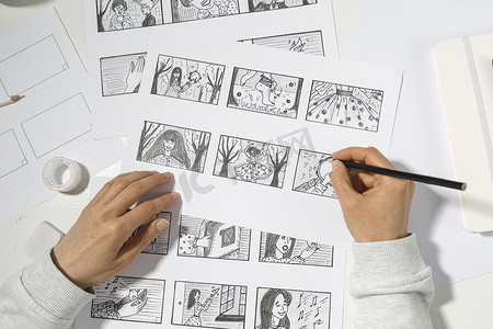 波普漫画摄影照片_漫画家用铅笔画了一幅漫画的故事板.影片的预制片。设计师为漫画创作草图. 