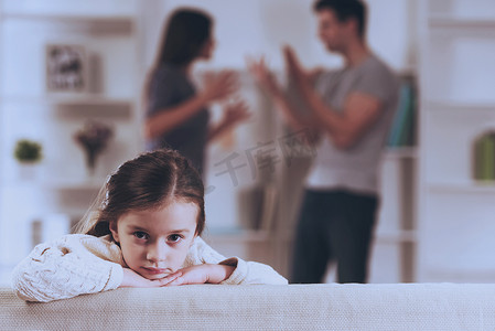 儿童郁闷摄影照片_悲伤的小女孩与争吵父母.