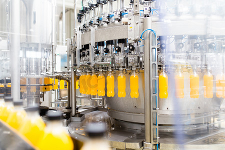 工装摄影照片_工业厂房和机械.苏打水和橙汁瓶加工装瓶机器人生产线.