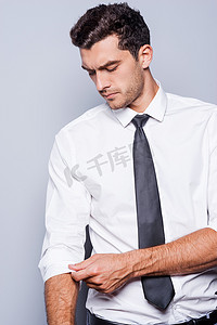 男人穿着衬衫和领带调整他的袖子