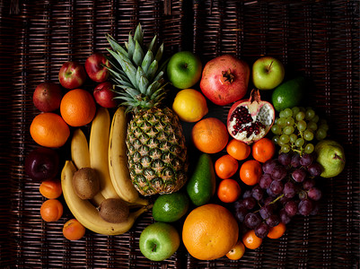 大量的水果采摘在明亮的复合水果躺在一个黑暗的柳条桌上, 每天维生素充电最美味和健康的水果