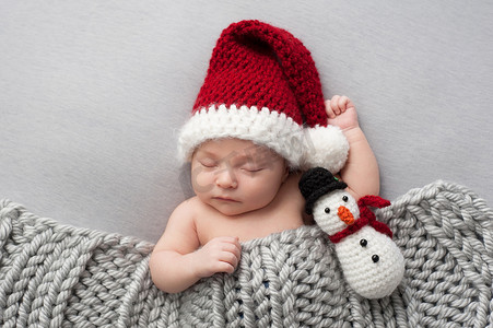 初生男婴与圣诞老人的帽子和雪人毛绒玩具