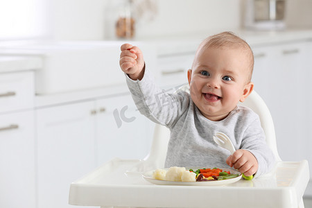 Cute little baby eating healthy food at home. Space for text