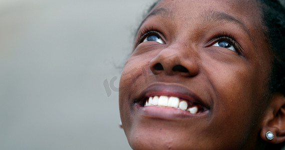Happy black African teen girl opening eyes outside smiling
