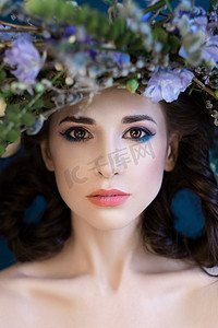 头带花环摄影照片_美丽的春姑娘带在头上的花环的特写肖像