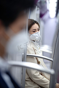 多职业人物摄影照片_年轻女人戴口罩坐地铁