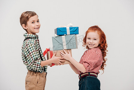 可爱的小孩子手持礼品盒, 微笑着在镜头上的灰色隔离