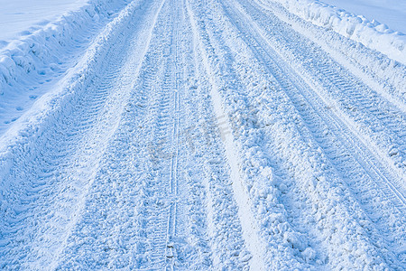 Texture of a snowy road with traces of car tires. Winter driving concept.