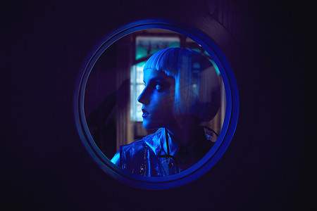 丝质摄影照片_未来的霓虹灯点燃肖像的惊人的女人与白色鲍勃发型穿着丝质上衣和透明雨衣在圆的窗口