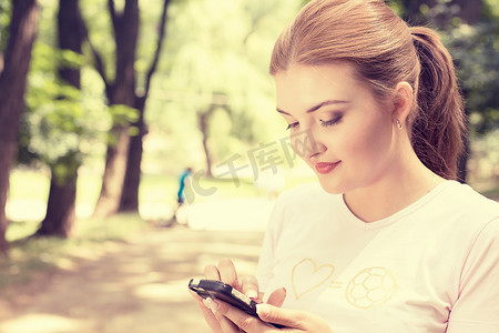what摄影照片_happy, cheerful, young woman excited by what she sees on cell phone texting 