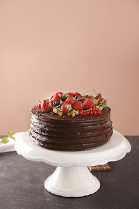 美味的巧克力蛋糕与草莓和葡萄干在桌子上的颜色背景