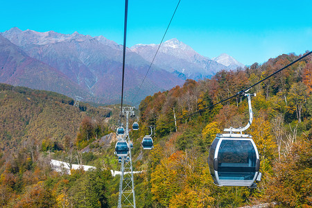 乘坐电梯摄影照片_可供游客乘坐的带滑雪电梯和小木屋的小木屋，游览城镇和山上的秋天森林.