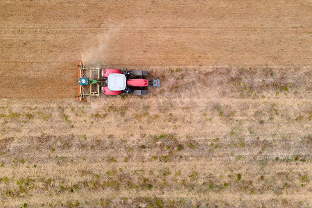 在田里犁地的拖拉机的无人驾驶航空图像