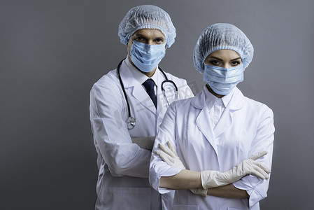 戴口罩的男医生摄影照片_男人和女人作为医生工作