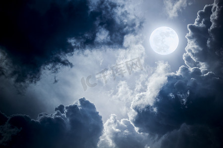 This dramatic photo illustration of a nighttime sky with brightly lit clouds and large, full, Blue Moon would make a great background for many uses.