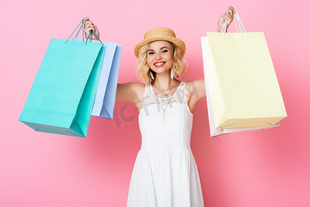 穿粉色衣服的女人摄影照片_头戴草帽，身穿白色衣服，提着粉色购物袋的女人 