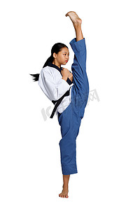 空手道跆拳道少女练习在黑带水平上打腿和高腿。亚洲青年女运动员穿着传统的运动服，而不穿白色背景的运动服
