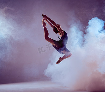 烟紫色摄影照片_美丽的年轻芭蕾舞演员跳上淡紫色的背景. 