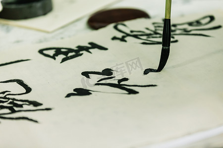 水墨笔刷效果摄影照片_笔迹用汉字写在纸上.笔刷在纸上.