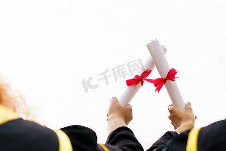 degree摄影照片_Happy Asian graduate student holding the diplomas on hand during the university graduation ceremony. Master degree student in gown suit holding a diplomas for photography.