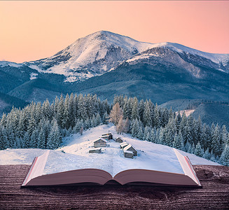 冬天的书摄影照片_小型高山山村在冬天的书页上打开一本神奇的书。雄伟的风景。自然与教育理念.