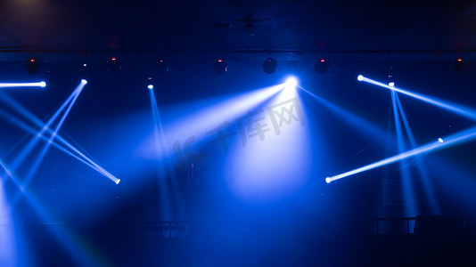 聚光灯灯光摄影照片_在迪斯科酒吧酒吧酒吧背景中，空旷的舞台音乐会与五彩缤纷的灯光激光束聚光灯在一起表演，为派对音乐节表演提供背景。娱乐夜生活。庆祝活动.