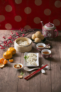 农历新年食品和饮料蒸饺子和装饰物品在木桌顶部. 