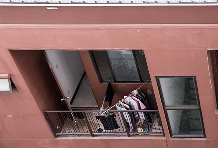 在泰国乌班市商业大厦的阳台上, 用工人的许多衣服清洗线路.