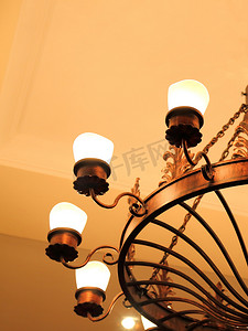 一个大型古董复古圆金属吊灯的青铜色与装饰元素挂在天花板上的金色背景与照明灯.