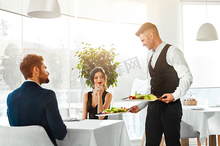 Food摄影照片_Love Couple Having Romantic Dinner In Restaurant. Healthy Food E