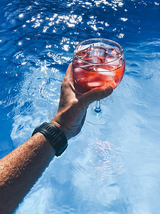 水池摄影照片_胳膊人鸡尾酒玻璃红色在水池.