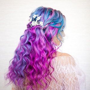 美丽健康的头发与明亮的颜色。长卷发紫色和粉红色色调