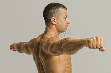 健美运动员表现出他背部、 肩膀、 肱三头肌和二头肌肌肉、 私人健身教练