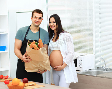 怀孕的妇女和她的丈夫准备饭菜.