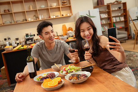 餐饮喝酒摄影照片_年轻夫妇在家用餐