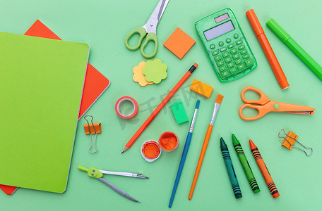 学习用品平铺.绿色背景的文具用品,顶视图.教育、重返校园、儿童创意概念