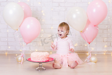生日和幸福的概念- -快乐的小女孩，背负着蛋糕和糖果，背负着彩灯和彩色气球