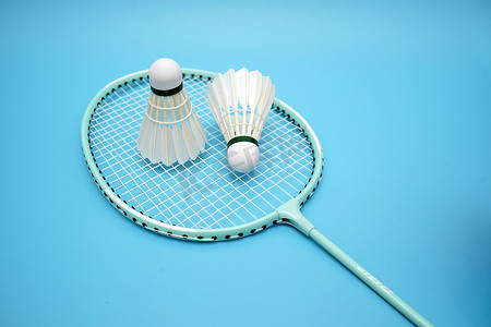 Badminton shuttlecock and badminton racket on blue background