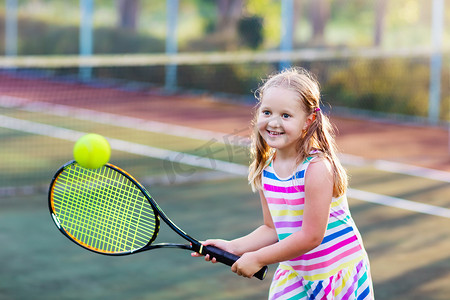 在室外篮球场上打网球的孩子