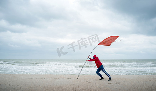 波涛汹涌的海上人挣扎与风岸上。红色标记表示强度的风.