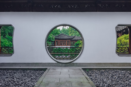 肝月亮城摄影照片_在中国杭州西湖附近的中国花园中, 通往赏见中国传统建筑的月亮门的道路