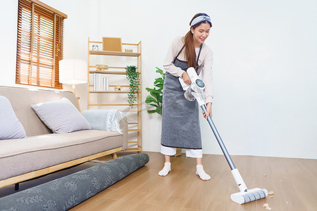 Housework concept, Housemaid use mop to mopping and cleaning dust on the floor in living room.