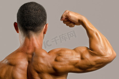 健美运动员表现出他背部、 肩膀、 肱三头肌和二头肌肌肉、 私人健身教练