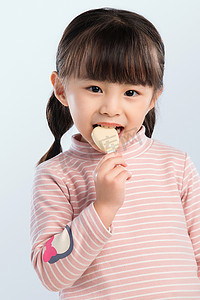 孩子吃零食摄影照片_可爱的小女孩正在吃零食