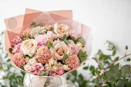 在木桌上的花瓶里, 美丽的新鲜切花花束。花商在花店的作品。精致的柔和色调颜色