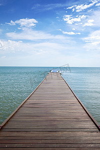 Wooden boardwalk above water out towards open ocean