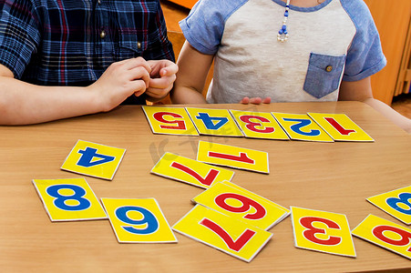 孩子们在玩 教育游戏。 幼稚园里的孩子 一个孩子的手。 数学药片.